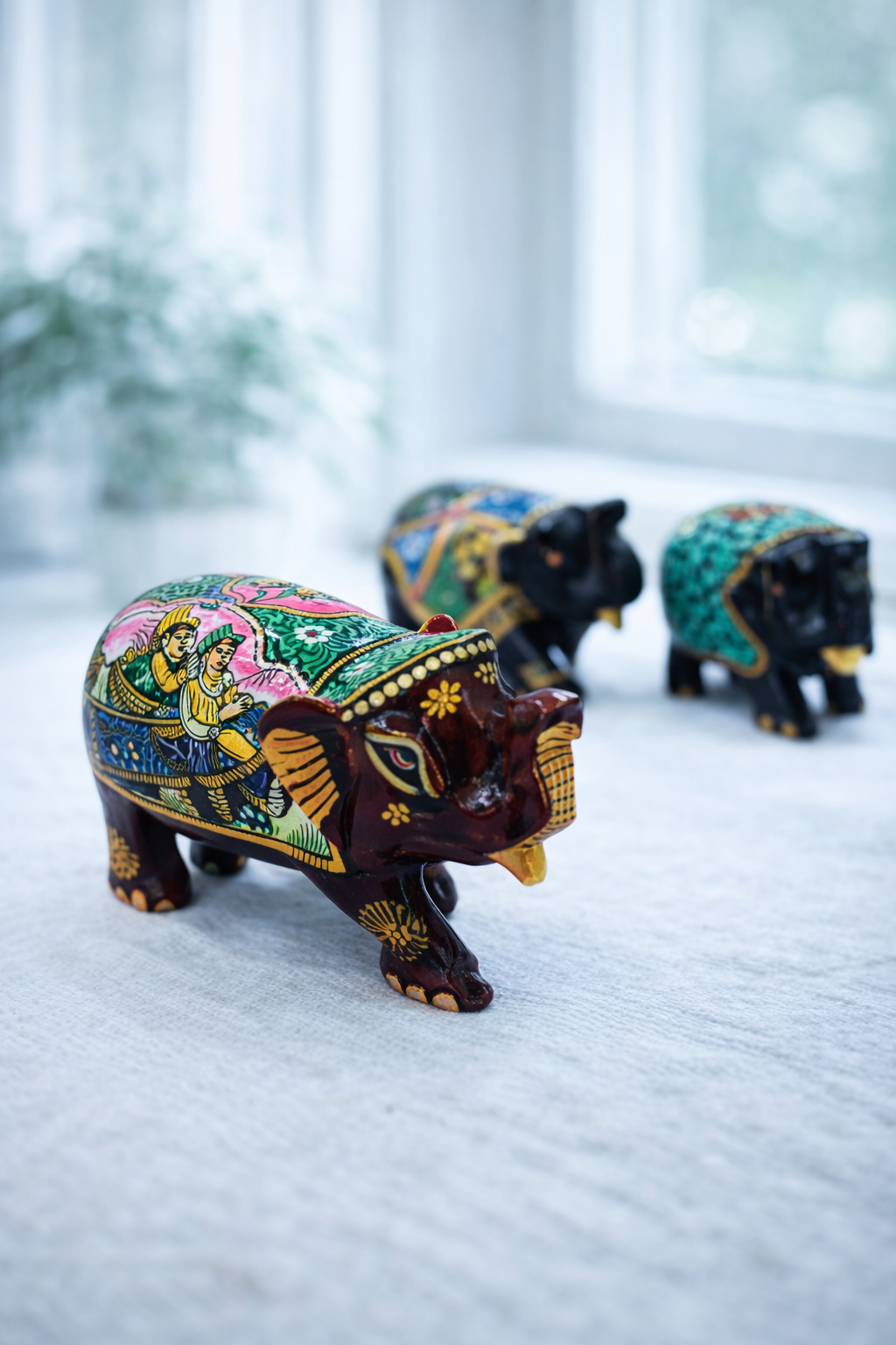 Hand‑painted Kala Haathi figurines with multicolour Rajasthani folk art on wooden surface
