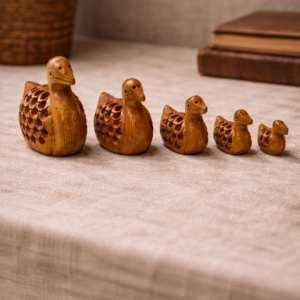 “Set of five hand‑carved serene drift duck figurines with hidden baby ducks inside lattice bodies; Kadamb wood specialty
