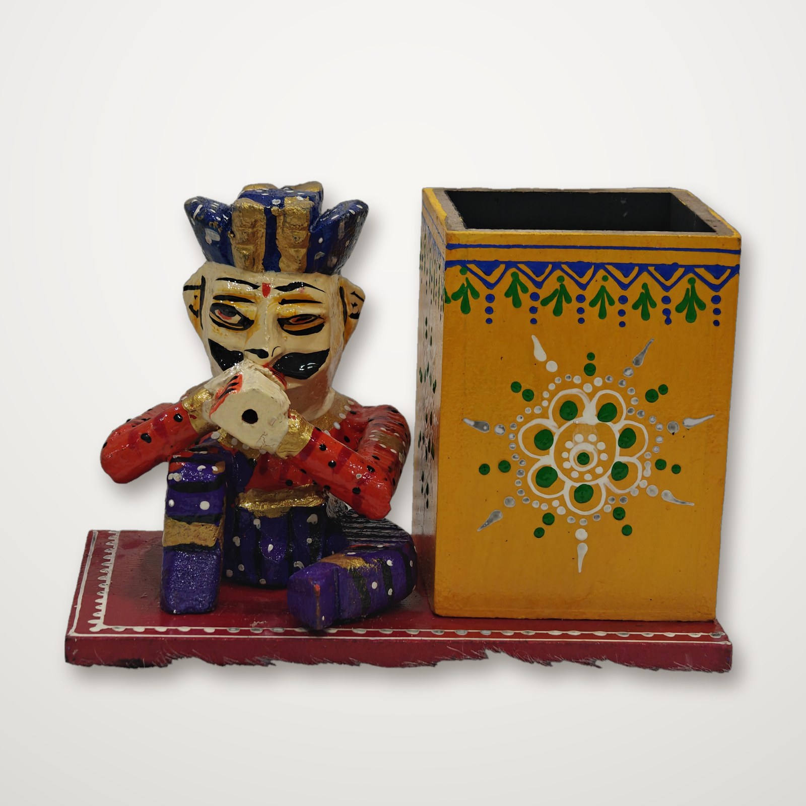 Folk art pen stand with a hand painted musician figure beside a painted pen box