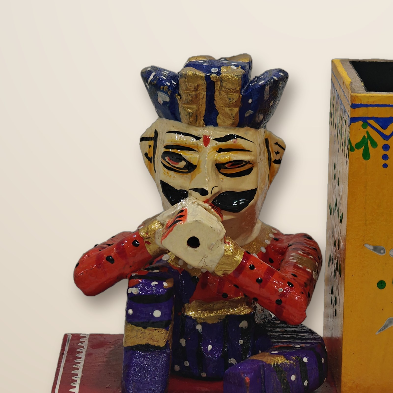 Close-up of the hand painted musician figure on the folk art pen stand