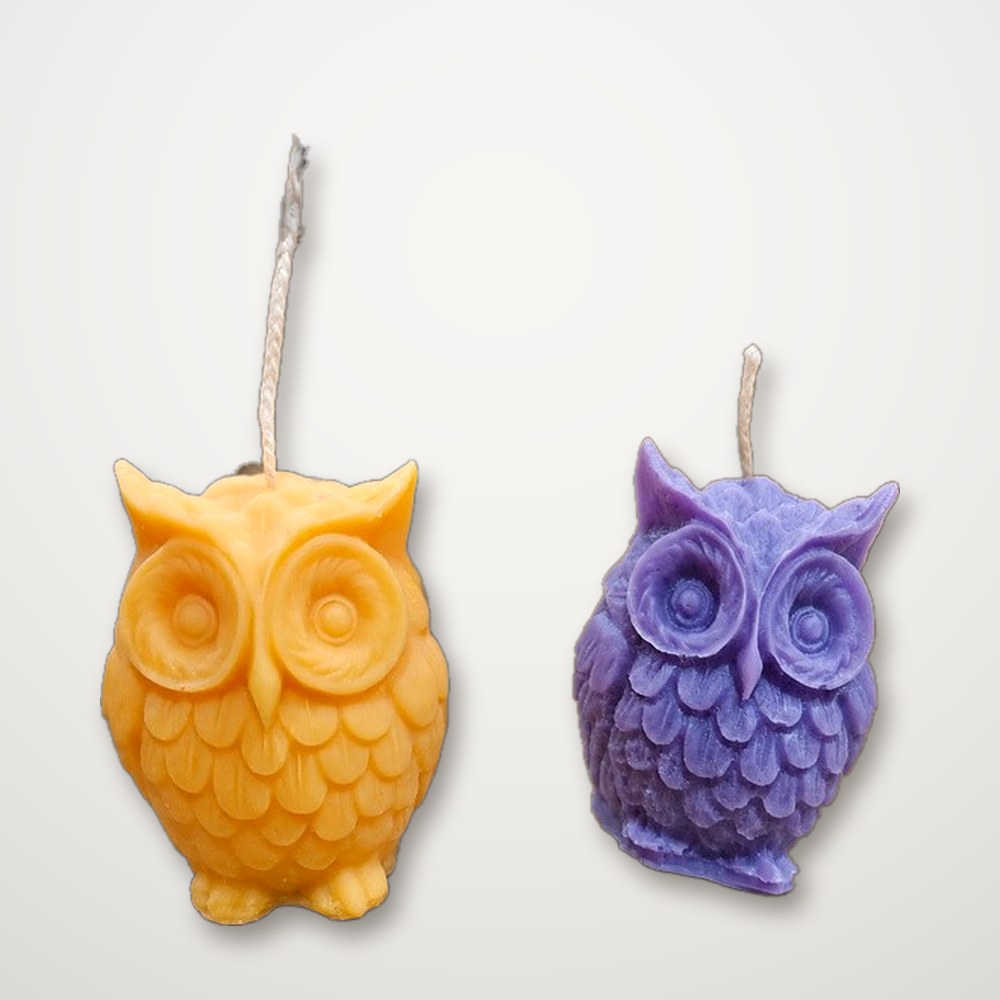 Yellow and purple Owl Candles side by side on a white background