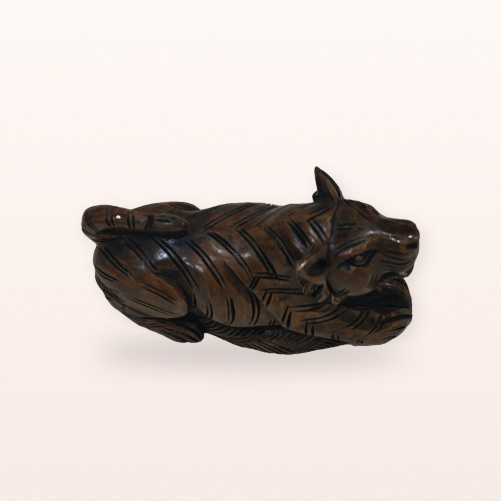 Polished Wooden Lion Figurine, on a soft blush background