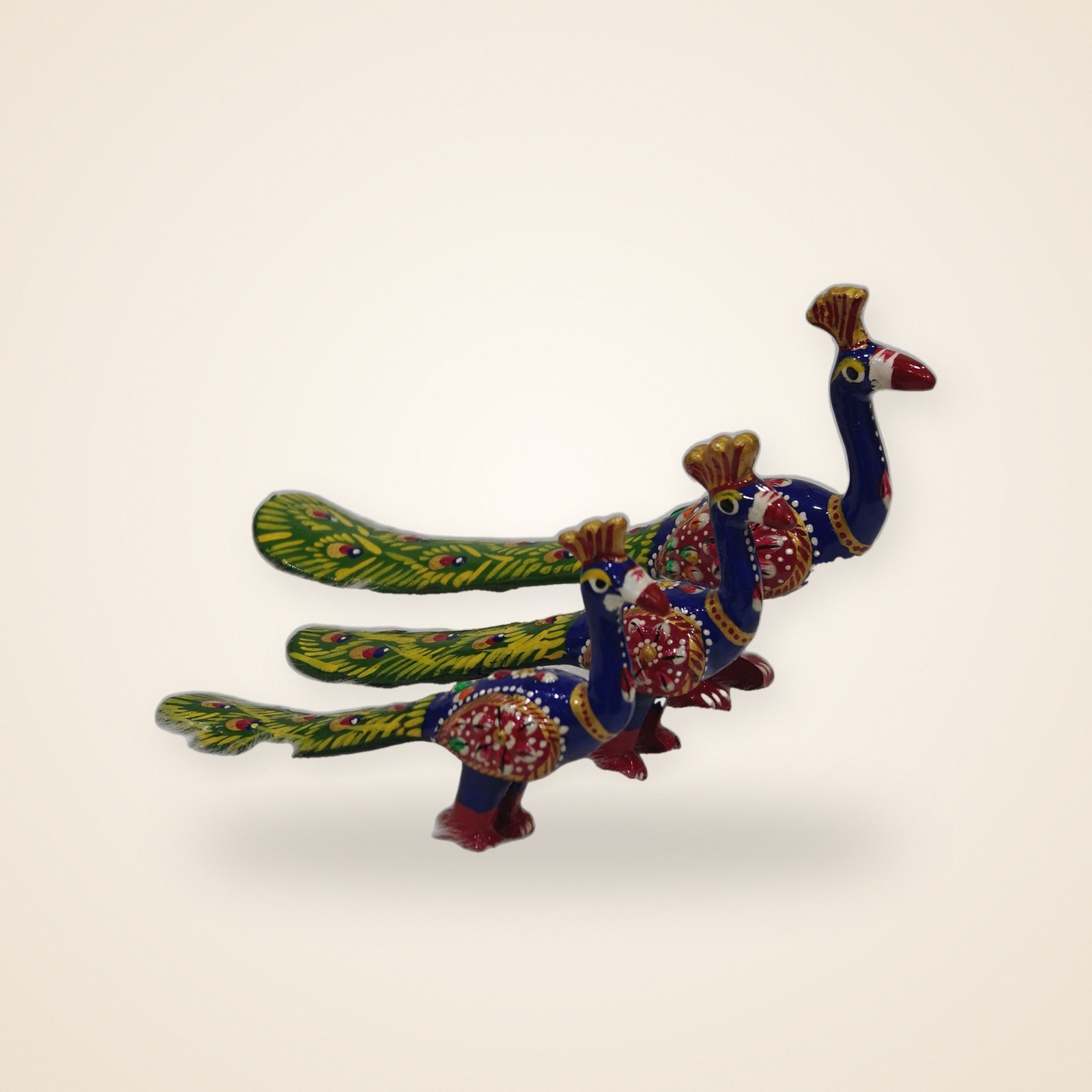 Blue Green Peacock figurines, on a cream background