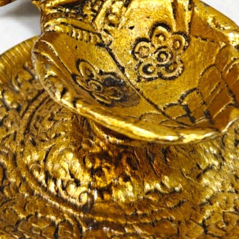 Close up of the embossed oil well and plate of the Lakshmi Ganesh Brass Diya