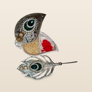 Peacock feather haldi kumkum box with spoon, on a cream background