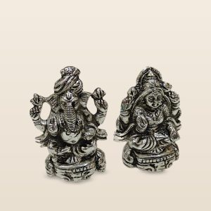 White metal Laxmi Ganesh idols, pair, on a cream background